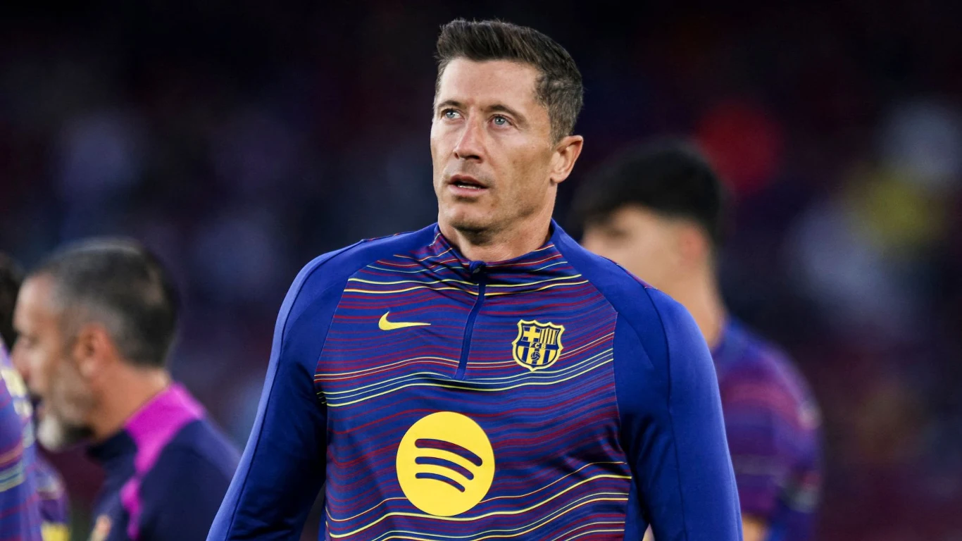 Piłkarz w stroju treningowym FC Barcelony z herbem klubu i logotypem sponsora na klatce piersiowej, skoncentrowany przed rozpoczęciem meczu.