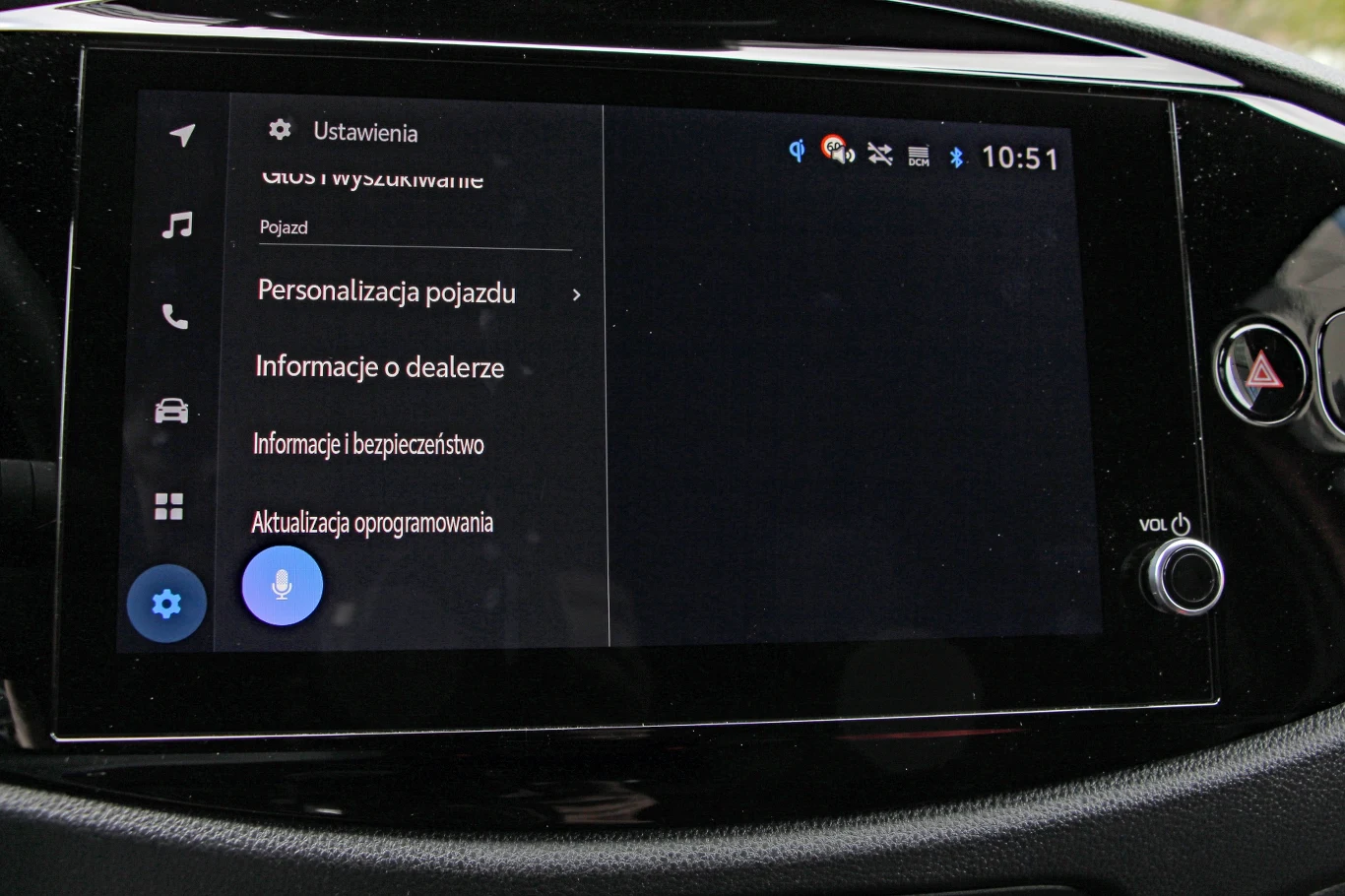 Toyota Aygo X Hybrid Ekran dotykowy systemu multimedialnego w samochodzie z widocznym menu ustawień, opcjami personalizacji pojazdu, informacji o dealerze, bezpieczeństwa oraz aktualizacji oprogramowania.