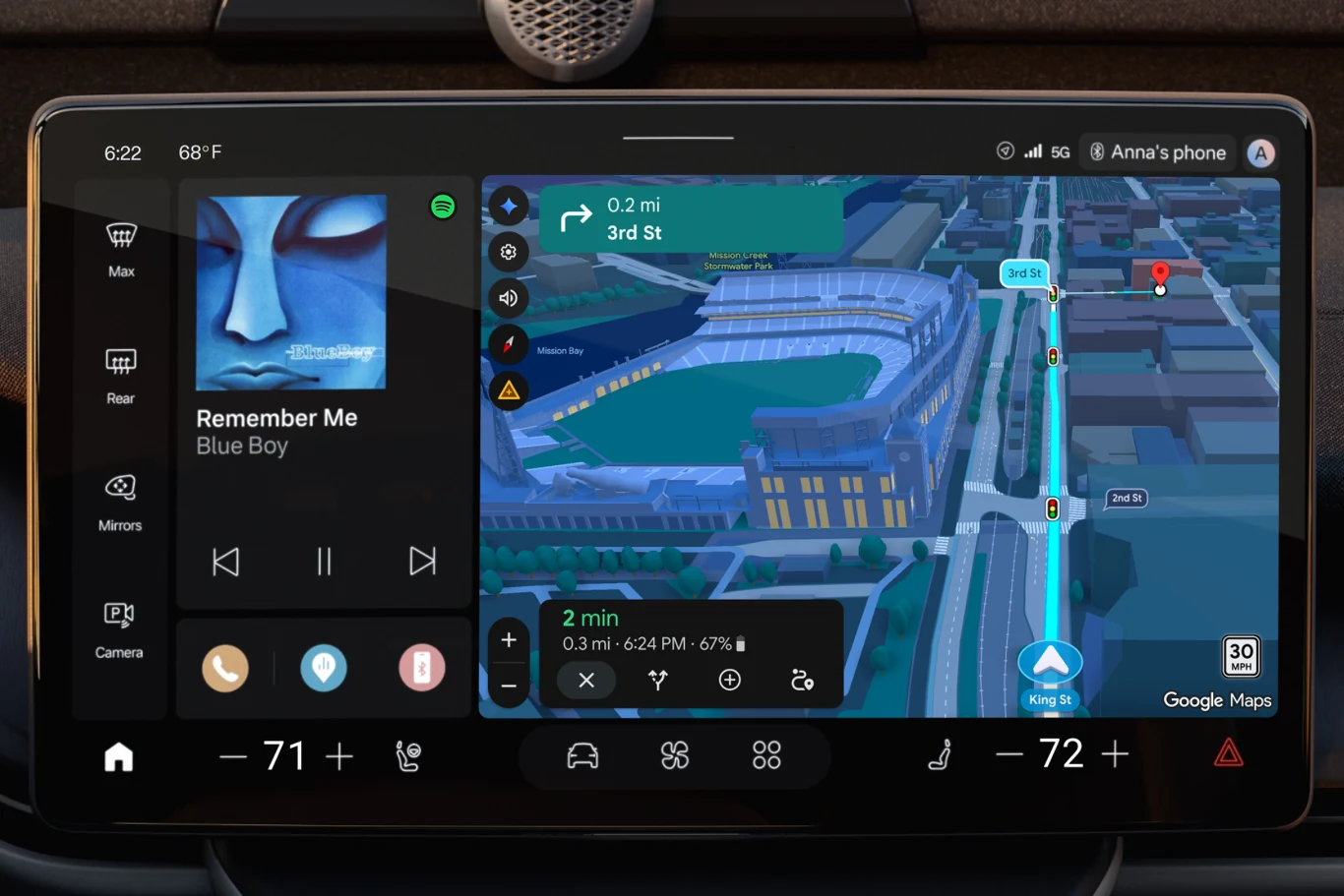 Ekran systemu multimedialnego samochodu wyświetlający po lewej stronie odtwarzacz muzyki z utworem 'Remember Me' zespołu Blue Boy, a po prawej szczegółową nawigację Google Maps z trójwymiarowym widokiem stadionu i trasą dojazdu.