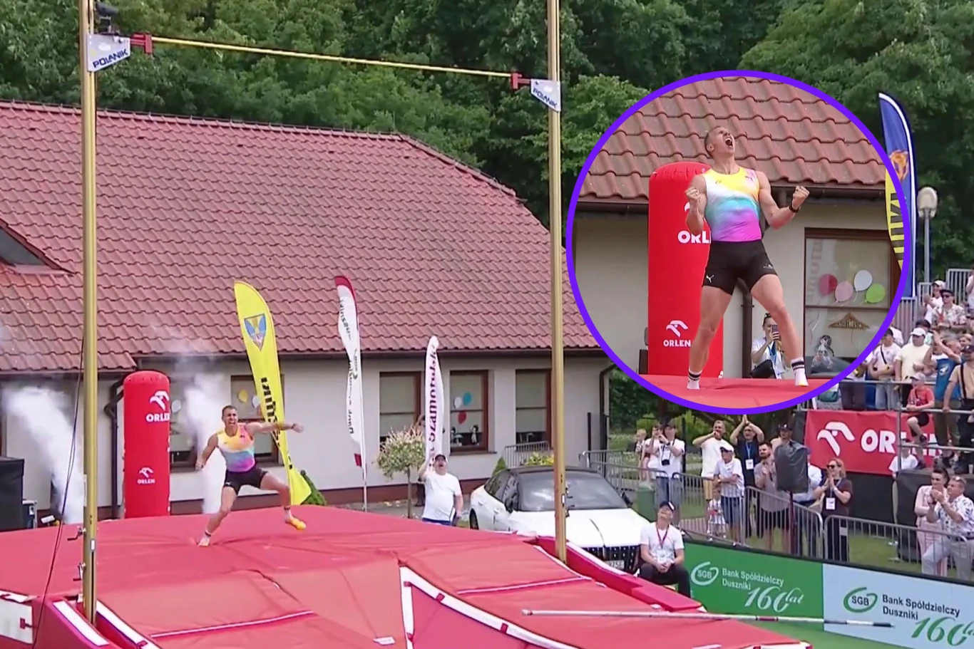 Lekkoatleta w kolorowym stroju świętuje udany skok o tyczce na stadionie lekkoatletycznym, otoczony przez kibiców i sędziów podczas zawodów na świeżym powietrzu.