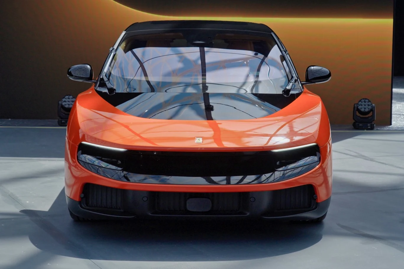 Ferrari Luce sprzedane na aukcji za 40 mln dolarów. Ferrari Luce, pomarańczowy elektryczny samochód z czarnym pasem na przodzie i reflektorami LED