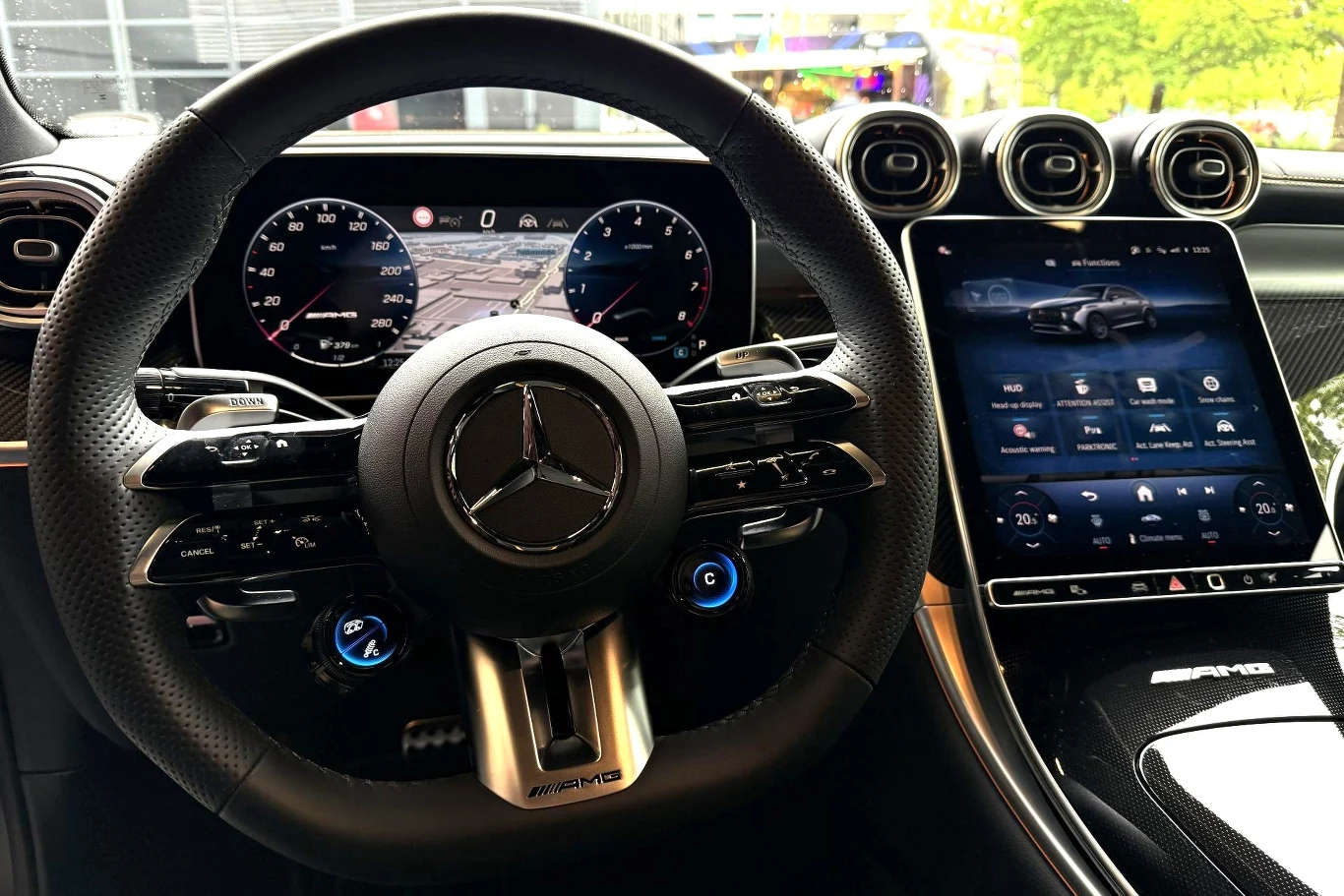 Kierownica z logo Mercedes-Benz, cyfrowy zestaw wskaźników z nawigacją oraz duży ekran dotykowy systemu multimedialnego w sportowej wersji AMG.