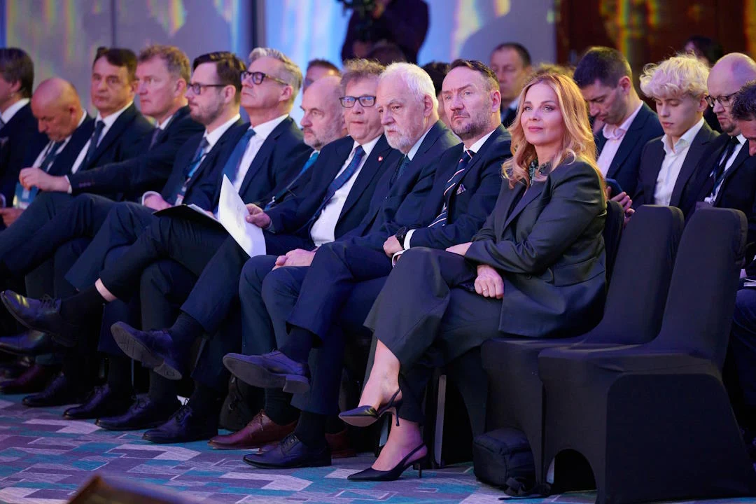 Przedstawicielka BGK oceniła, że resort rozwoju i technologii, planując programy mieszkaniowe, próbuje mierzyć się bieżącymi potrzebami Grupa osób w eleganckich garniturach i formalnych strojach siedzi w pierwszym rzędzie na wydarzeniu, z poważnymi minami skupionymi na scenie lub prelegencie.