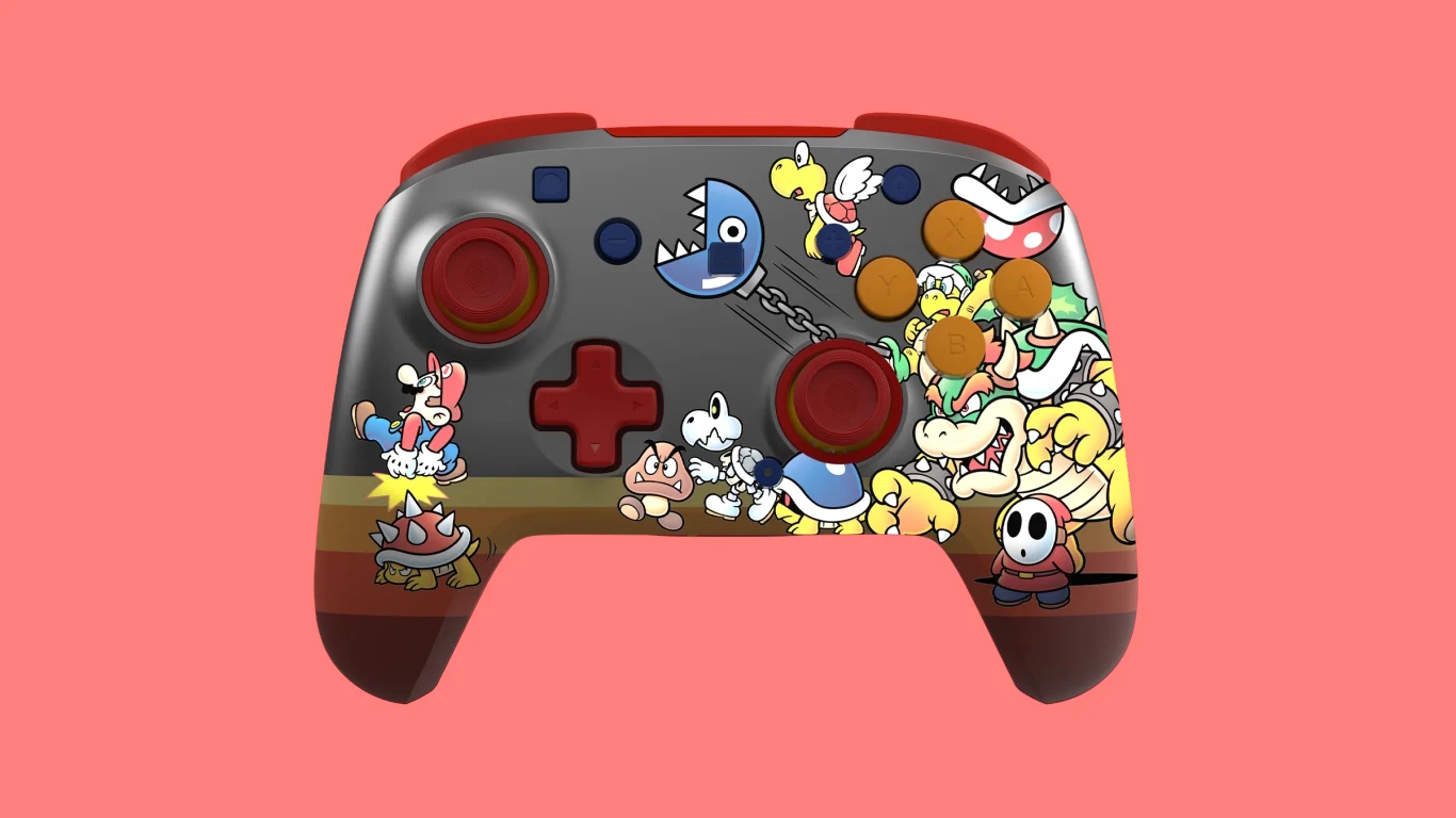 Kolorowy kontroler do gier ozdobiony postaciami z serii Mario, takimi jak Bowser, Shy Guy, Goomba oraz inne klasyczne postacie z gier Nintendo, na tle intensywnego różowego koloru.