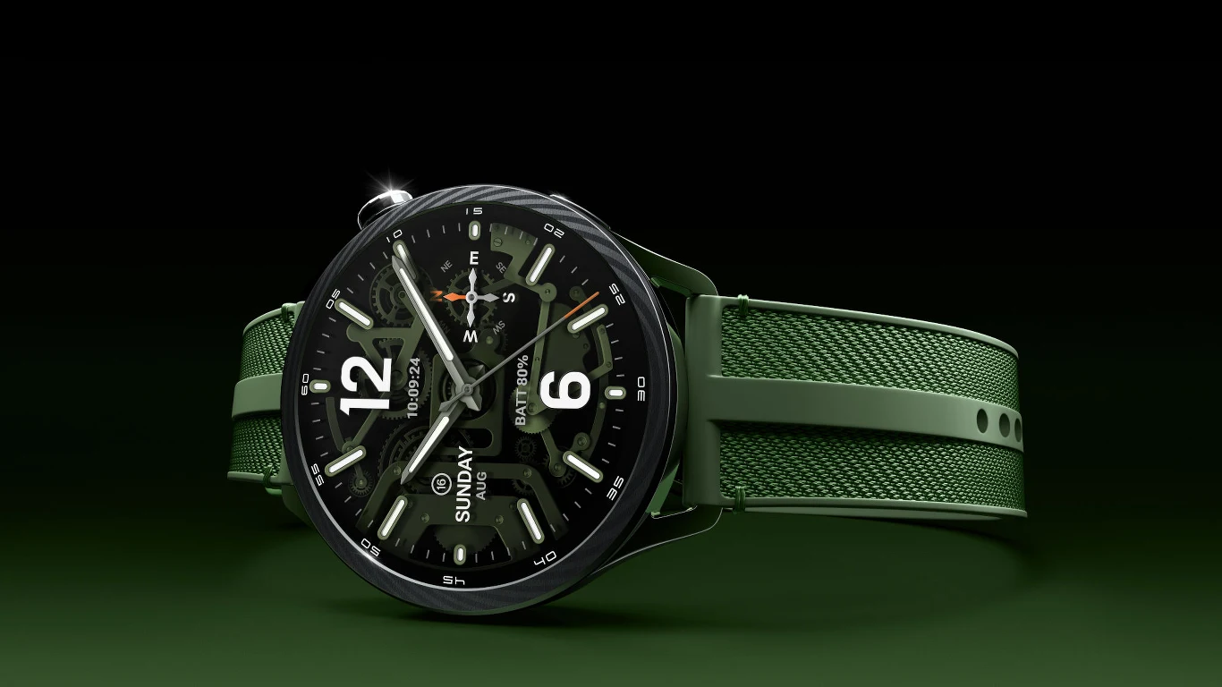 Zielony smartwatch z okrągłą tarczą, wyraźnymi białymi cyframi i indeksami, wyświetlający datę oraz godzinę, z funkcją wskazującą dzień tygodnia i liczne opcje dostępne na ekranie dotykowym.