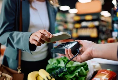 Karta Kaufland XTRA — dłoń z kartą lojalnościową przy kasie samoobsługowej w supermarkecie