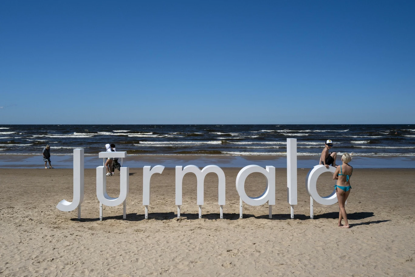 Morze Bałtyckie ma swoją ukrytą perełkę. Jurmała zachwyca szerokimi plażami Napisa Jurmała na szerokiej piaszczystej plaży nad Morzem Bałtyckim to jeden z charakterystycznych punktów tej miejscowości.