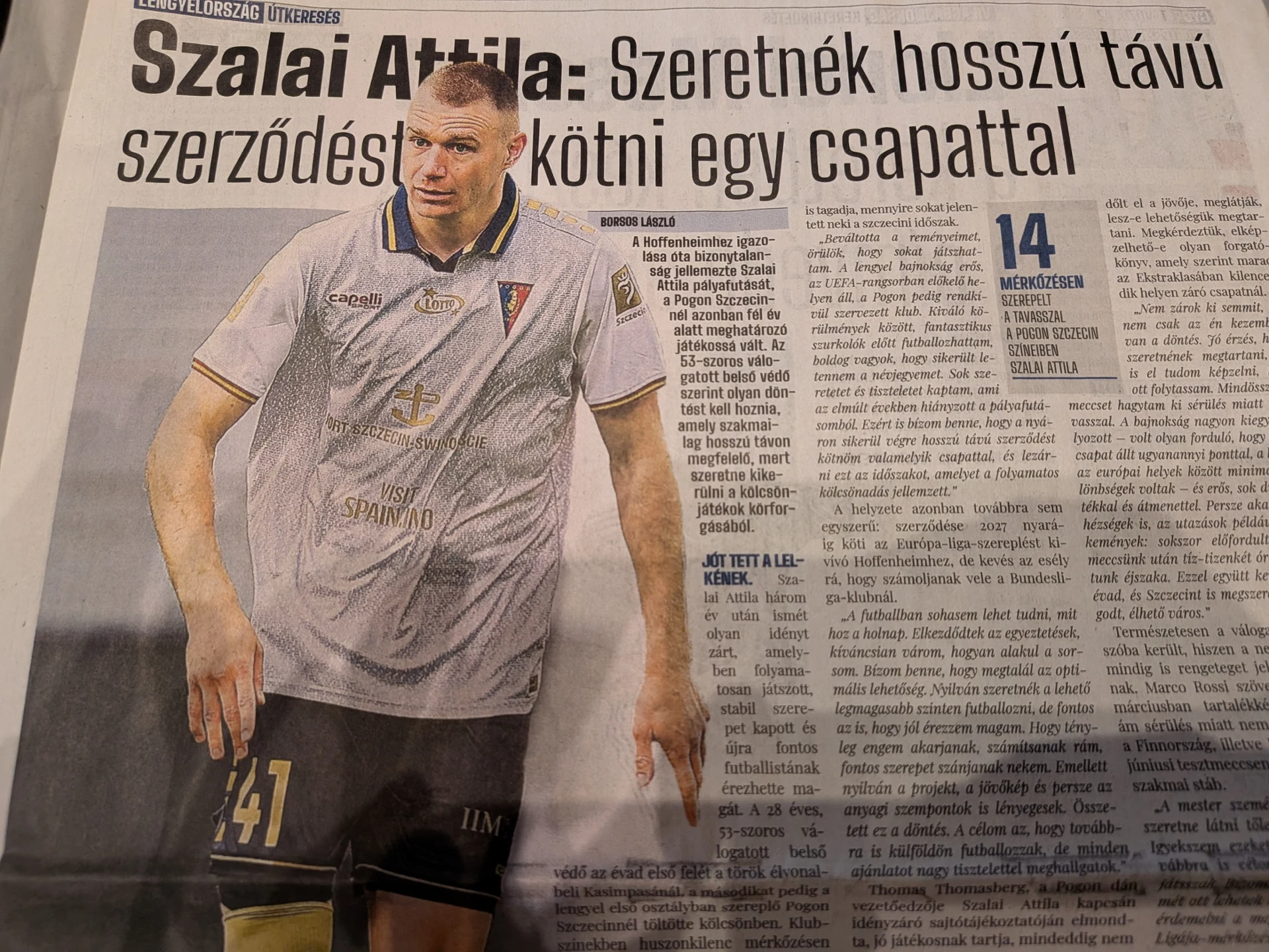 Piłkarz w biało-granatowej koszulce z numerem 41 oraz nazwiskiem Szalai Attila stoi w dynamicznej pozie, obok znajduje się artykuł z dużym nagł&oacute;wkiem w języku węgierskim, poświęcony jego wypowiedzi na temat przyszłości sportowej.