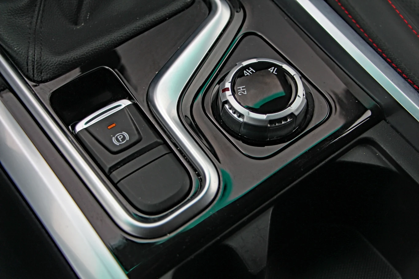 Panel sterowania napędem 4x4 z pokrętłem trybów jazdy oraz przyciskiem elektrycznego hamulca ręcznego.