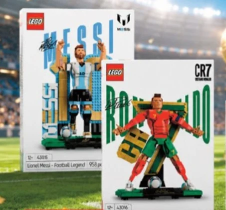 Dwie opakowania zestawów LEGO przedstawiające kultowych piłkarzy, Messiego i Ronaldo, ustawione jedno za drugim na tle stadionu piłkarskiego.