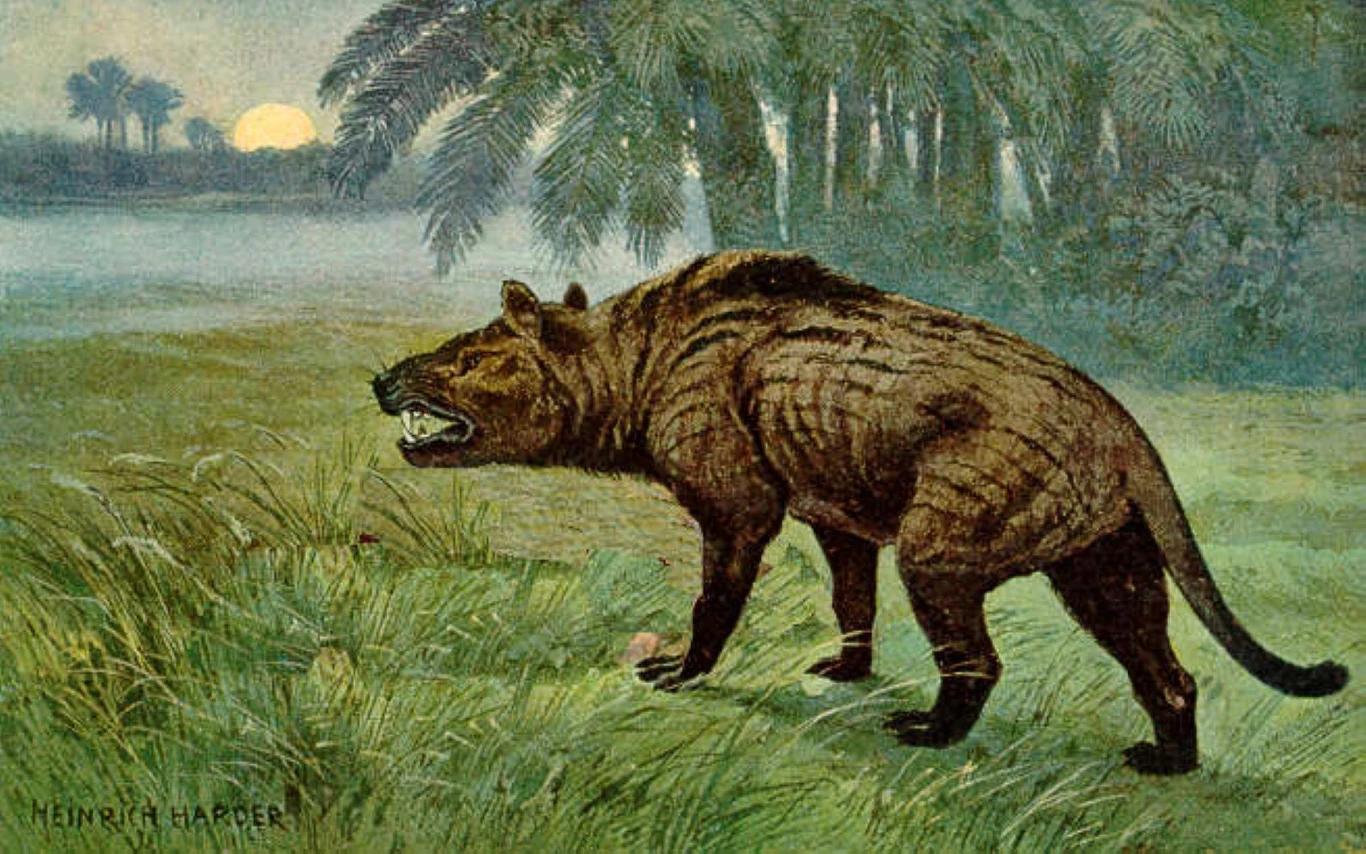 Prehistoryczne zwierzę o masywnej sylwetce i otwartej paszczy, stojące na zielonej trawie w pobliżu tropikalnych palm i rzeki, z zachodzącym słońcem w tle.