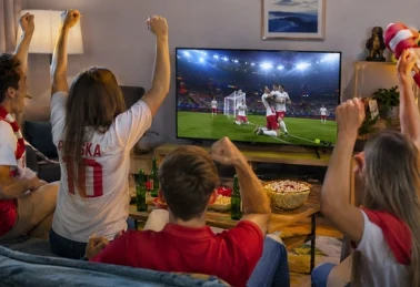 Kibice w koszulkach reprezentacji Polski świętują gola podczas meczu mundialu 2026, na stole piwo i przekąski z Żabki 