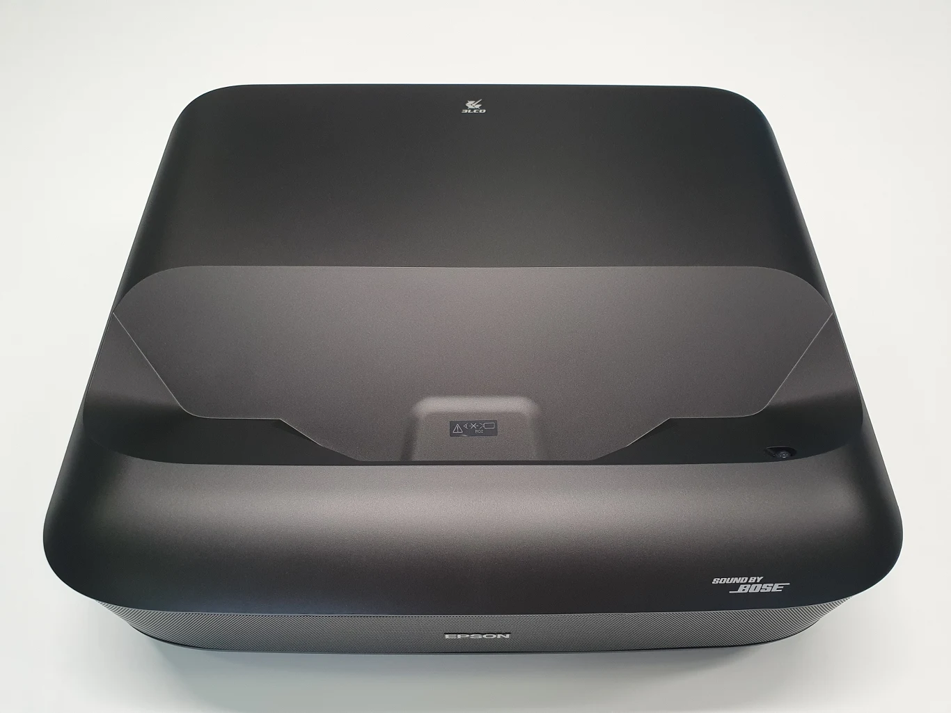 Lifestudio Grand EH-LS670 Czarny projektor multimedialny z logo marki Epson oraz zestawem głośników sygnowanych przez Bose, ustawiony na białej powierzchni.
