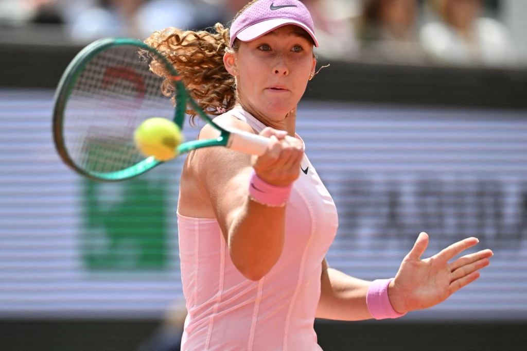 Mirra Andriejewa wygrała Roland Garros 2026 Tenisistka w różowym stroju i czapce odbija piłkę rakietą podczas meczu na korcie.
