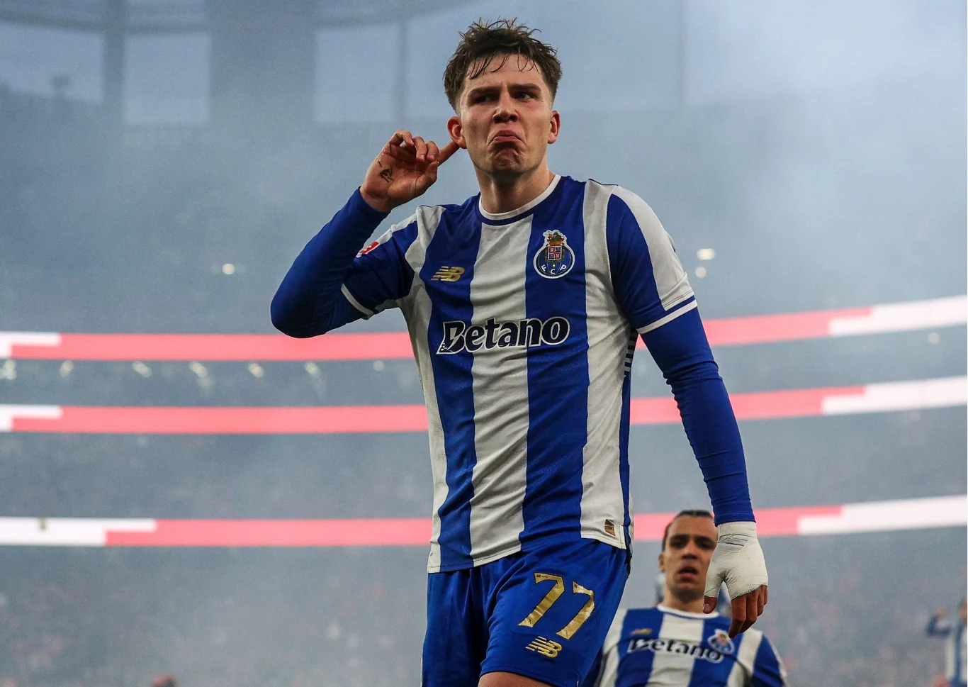 Oskar Pietuszewski Oskar Pietuszewski w stroju FC Porto świętuje bramkę gestem dłoni przy uchu na stadionie podczas meczu.