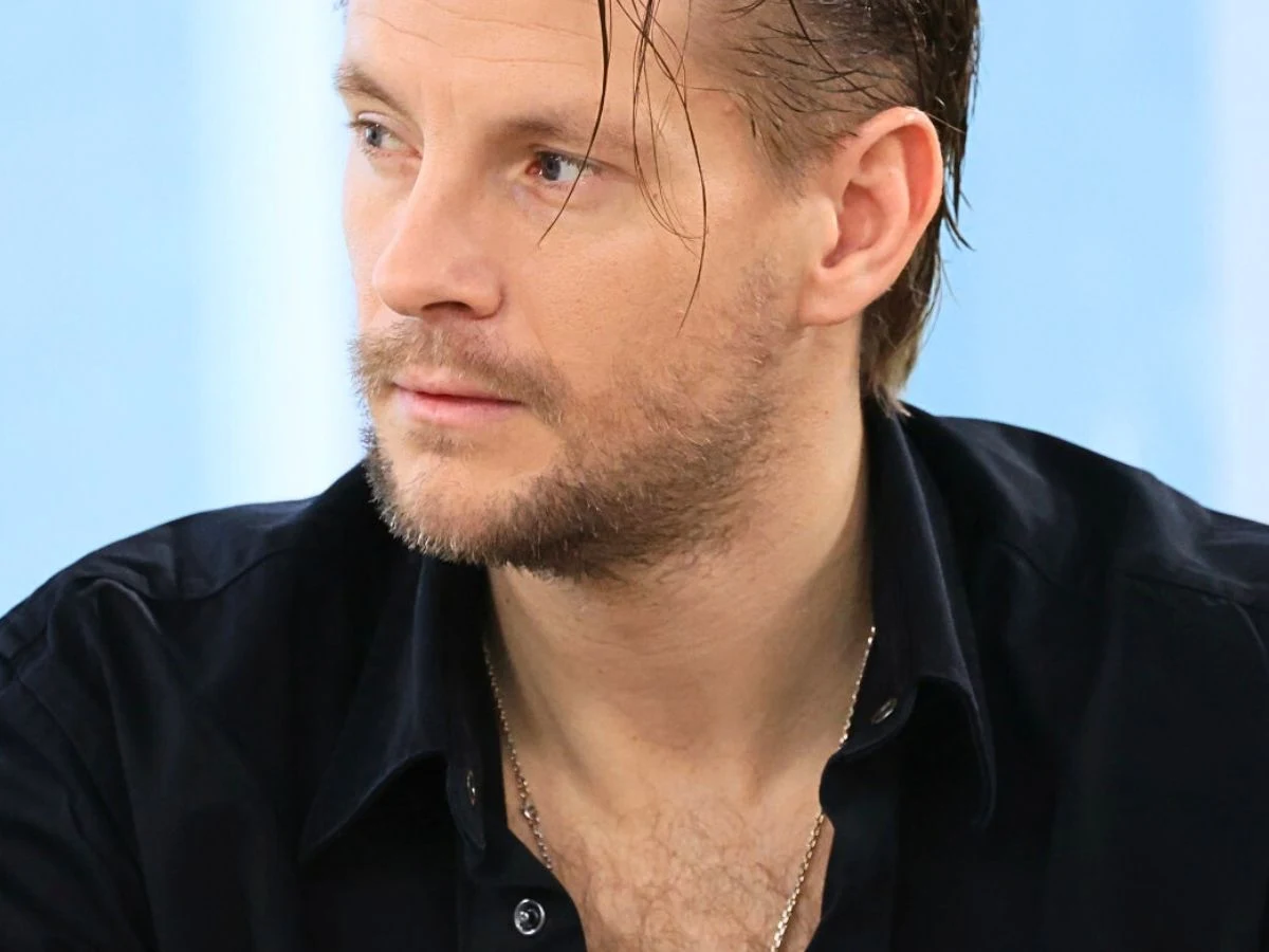 Sebastian Fabijański Sebastian Fabijański na festiwalu w Opolu. Aktor ma na sobie czarną marynarkę i biały golf.