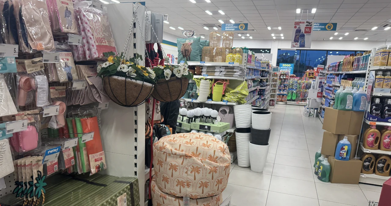 Kupiłam dwie pufy w Dealz i nie żałuję. Ten dodatek potrafi odmienić wnętrze Alejka w sklepie Dealz z donicami, poduszkami, koszami i środkami czystości na półkach.