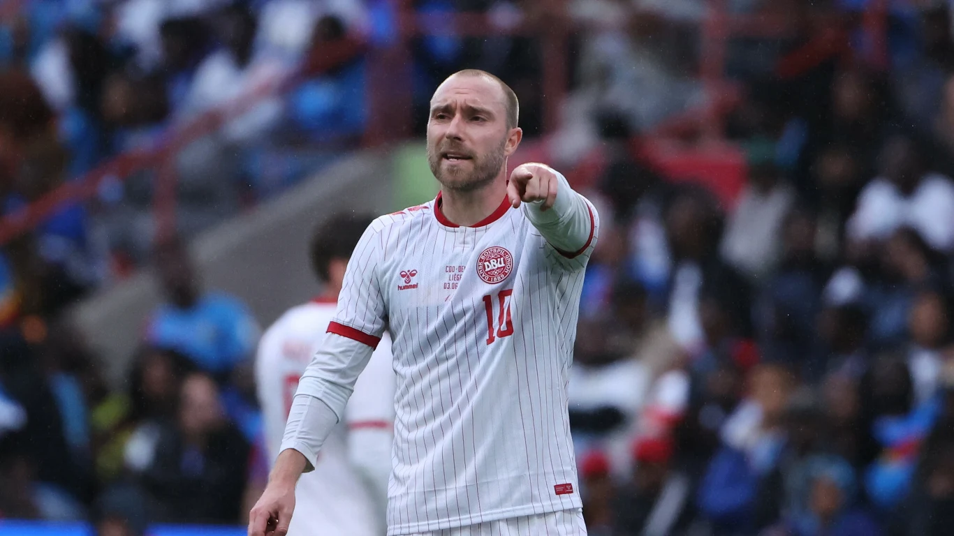 Christian Eriksen Piłkarz w biało-czerwonym stroju z numerem 14 wskazuje coś ręką podczas meczu, koncentrując uwagę.