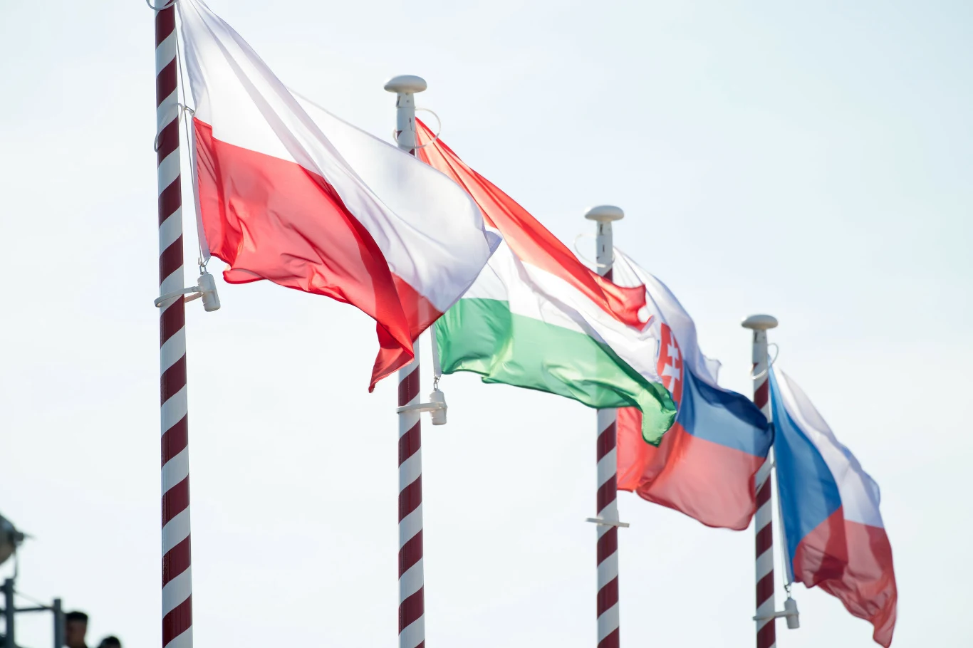 Nowy rozdział w relacjach Węgier z Polską i V4 Cztery flagi narodowe: Węgier, Polski, Czech, Słowacji na masztach, powiewających na wietrze.