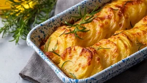 Potato gratin - gratin (baked potatoes with cream and cheese) with rosemary and forks