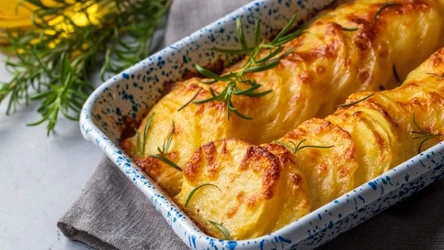 Potato gratin - gratin (baked potatoes with cream and cheese) with rosemary and forks