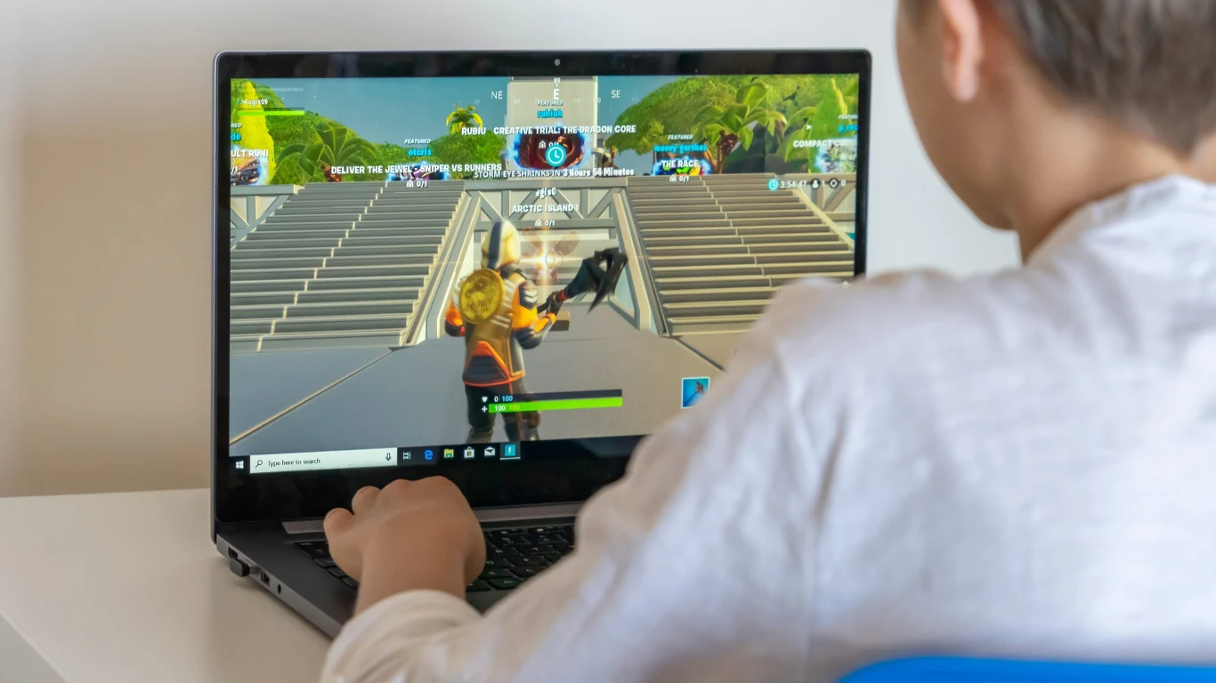 11-latek ukradł rodzicom pieniądze na czarną godzinę. Wszystko wydał w grze Roblox Chłopiec grający na laptopie w grę Roblox, postać w widoku trzeciej osoby biegnie po schodach w wirtualnym świecie