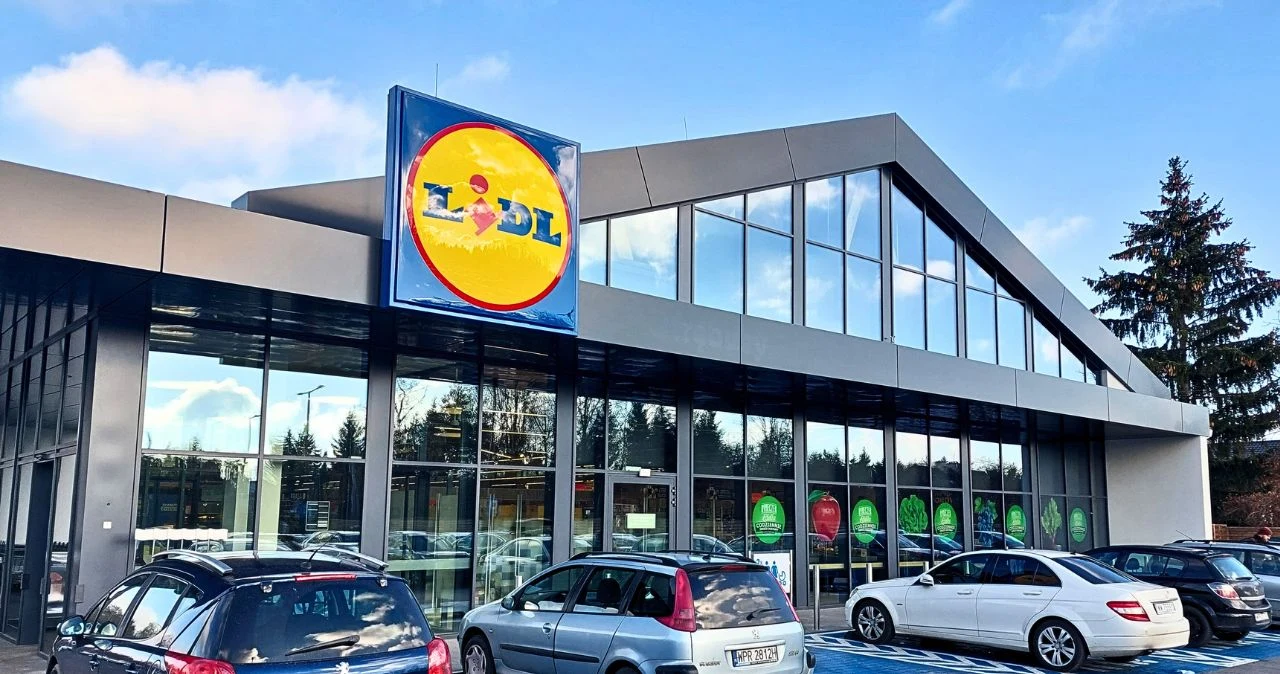 Lidl do 13 czerwca: promocje „za grosz”, 1+1 gratis i rabaty w Lidl Plus. Co naprawdę się opłaca? Nowoczesny market Lidl z przeszklonymi ścianami, widoczne zaparkowane samochody przed wejściem.