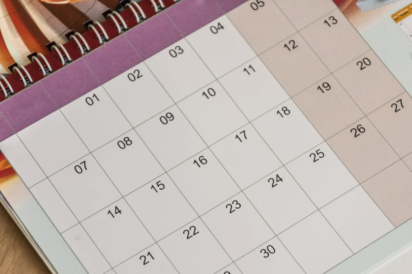 W numerologii daty mają wyjątkowe znaczenie Strona papierowego kalendarza z układem miesięcznym, wyraźnie zaznaczone numerowane dni bez dodatkowych notatek i oznaczeń.