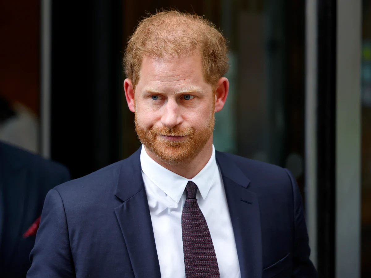 Książę Harry Książę Harry w garniturze przed wejściem do budynku.