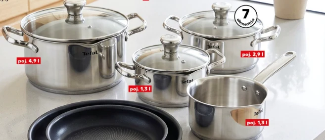 Zestaw garnków Tefal Duetto++ Zestaw garnków ze stali nierdzewnej z pokrywkami, widoczne cztery garnki o różnych pojemnościach oraz dwie czarne patelnie umieszczone z przodu zestawu.