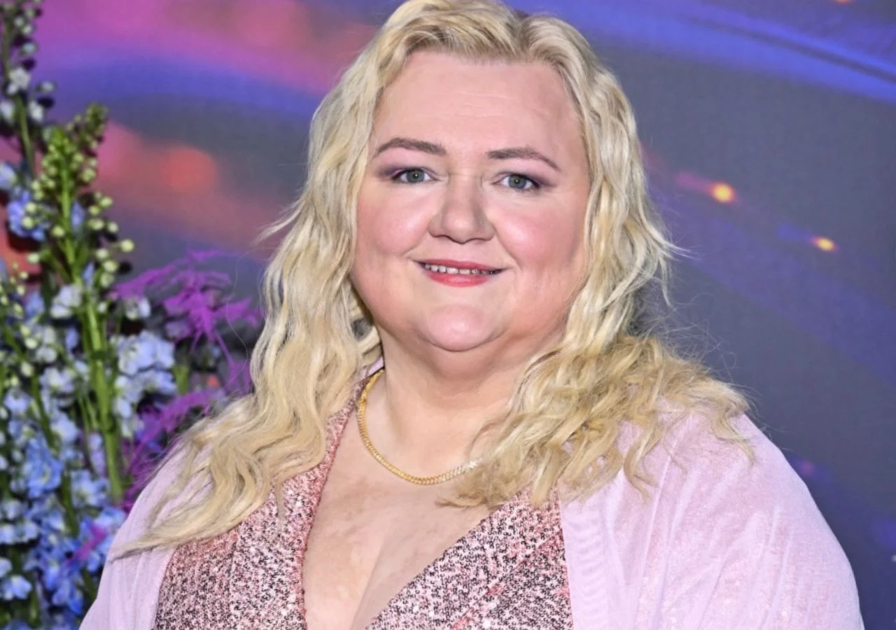 Manuela Michalak Manuela Michalak w błyszczącej sukni pozuje na tle kwiatów i kolorowych dekoracji