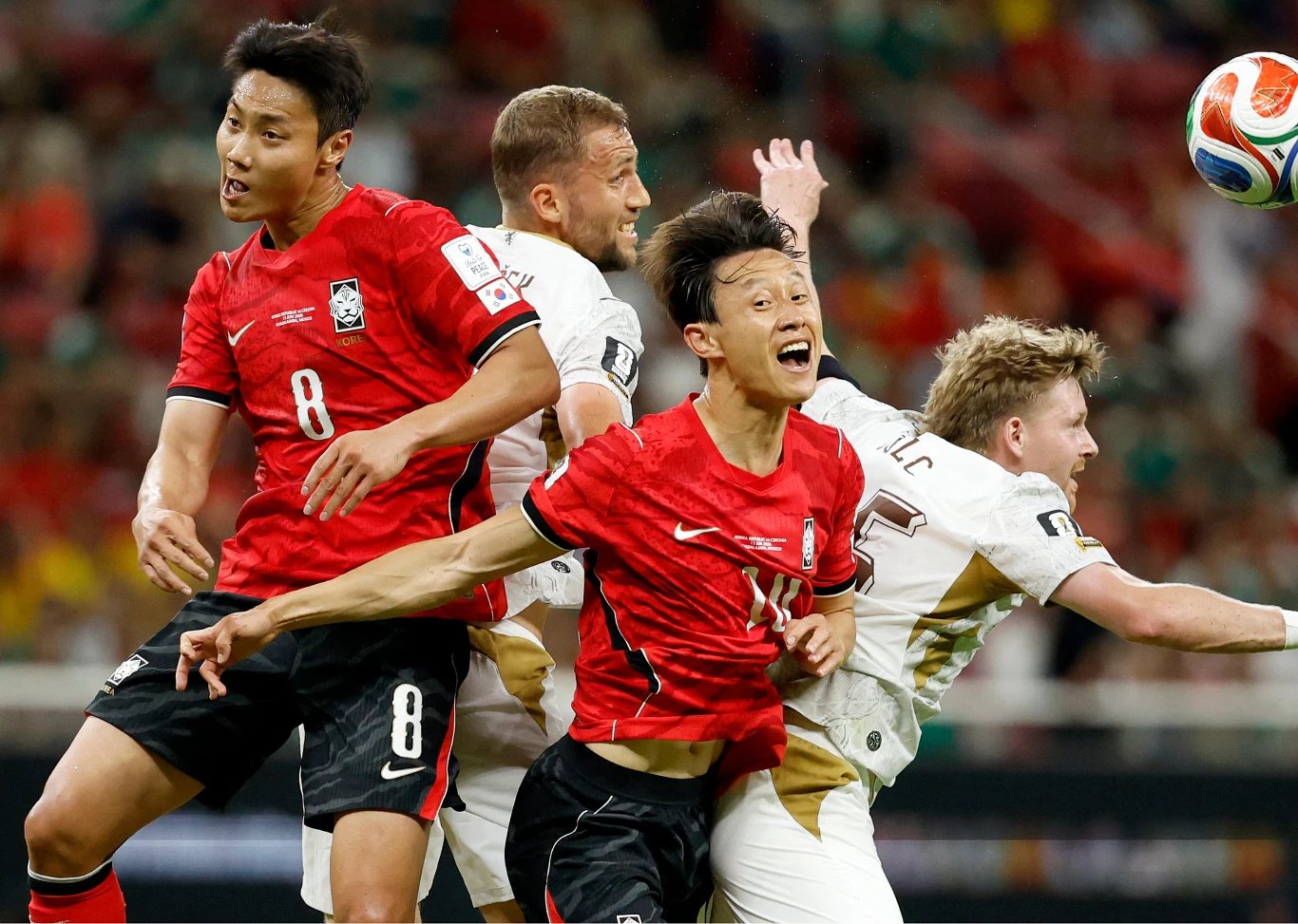 Mistrzostwa świata 2026. Kadr z meczu Korea Południowa - Czechy Mecz Korea Południowa - Czechy. Piłkarze w czerwonych i białych koszulkach walczą o piłkę głową.