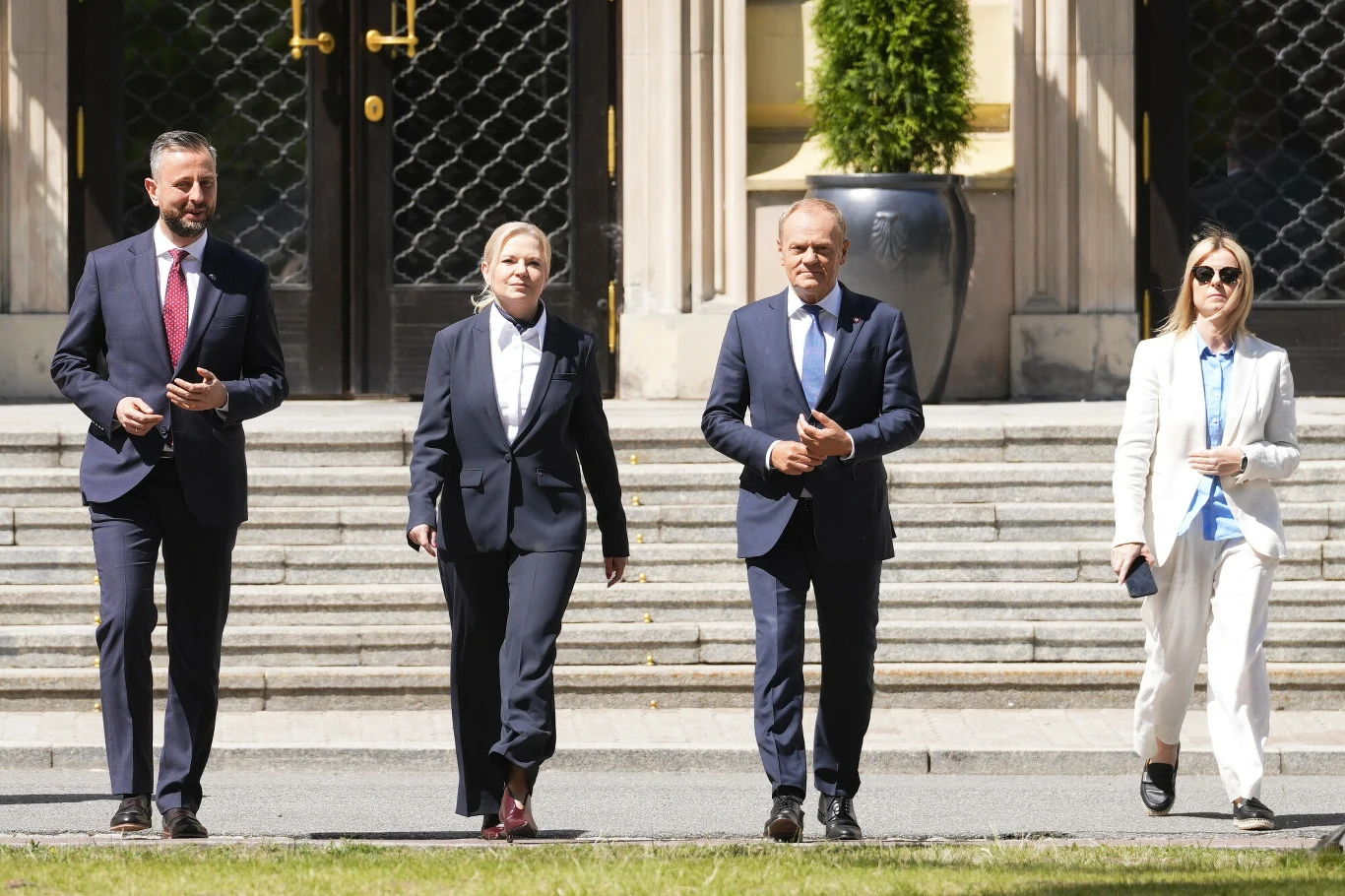 Monika Piątkowska - wspólna kandydatka KO i PSL Monika Piątkowska z KO oraz Władysław Kosiniak-Kamysz i Donald Tusk w garniturach idą alejką przed reprezentacyjnym budynkiem.