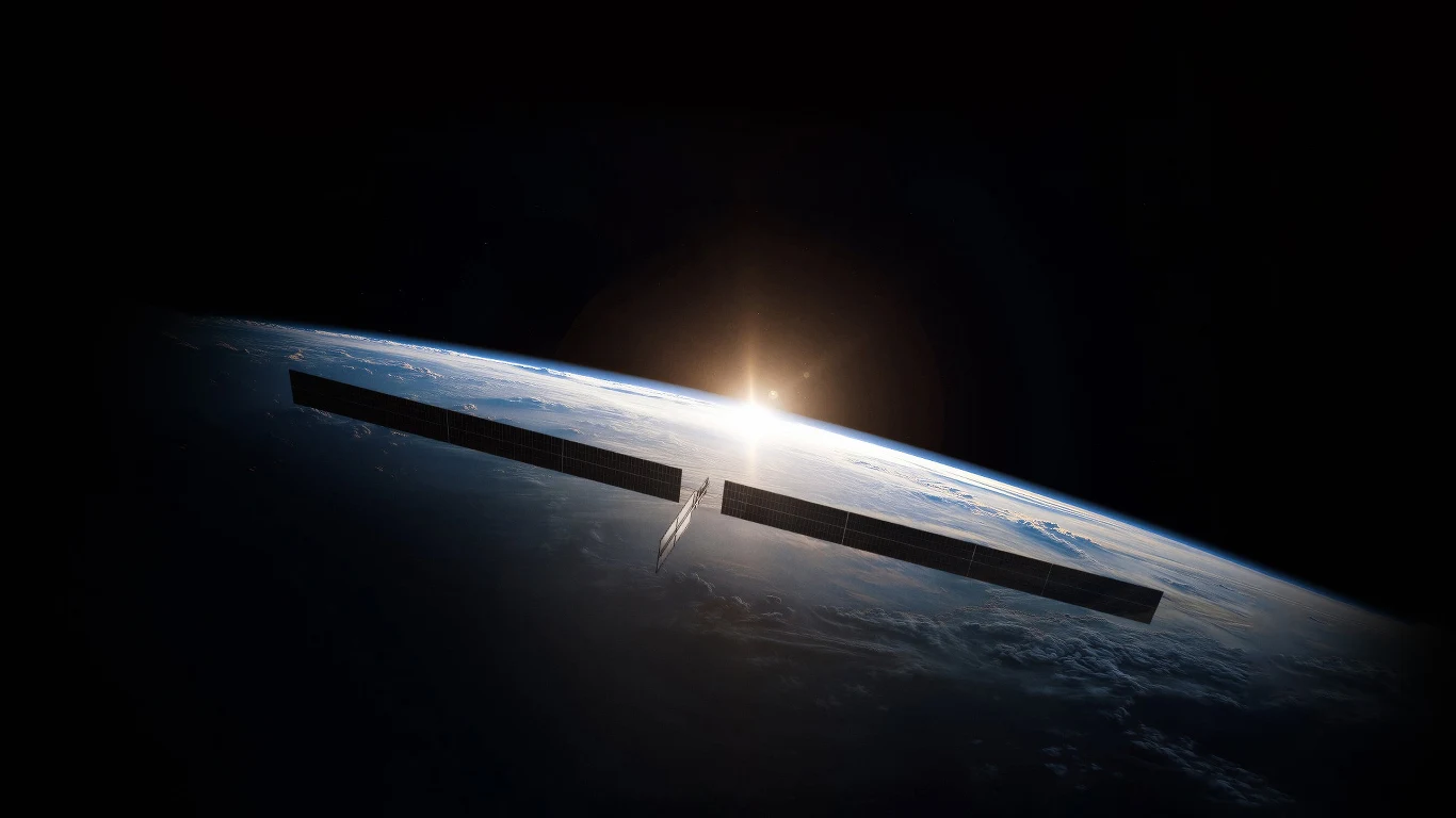 Satelita SpaceX z panelami słonecznymi nad zakrzywionym horyzontem Ziemi na tle wschodzącego Słońca.