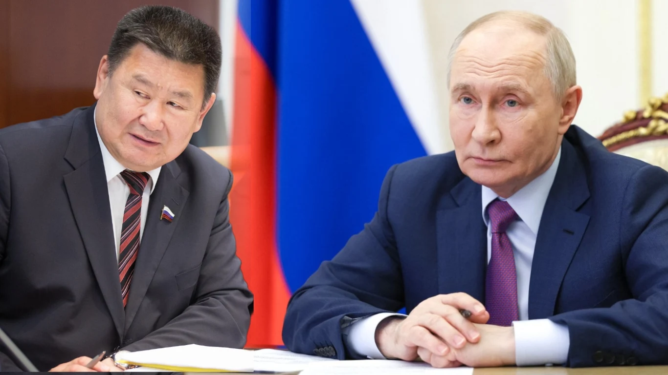 Wiaczesław Marchajew i Władimir Putin w garniturach przy biurku z dokumentami, w tle rosyjska flaga.