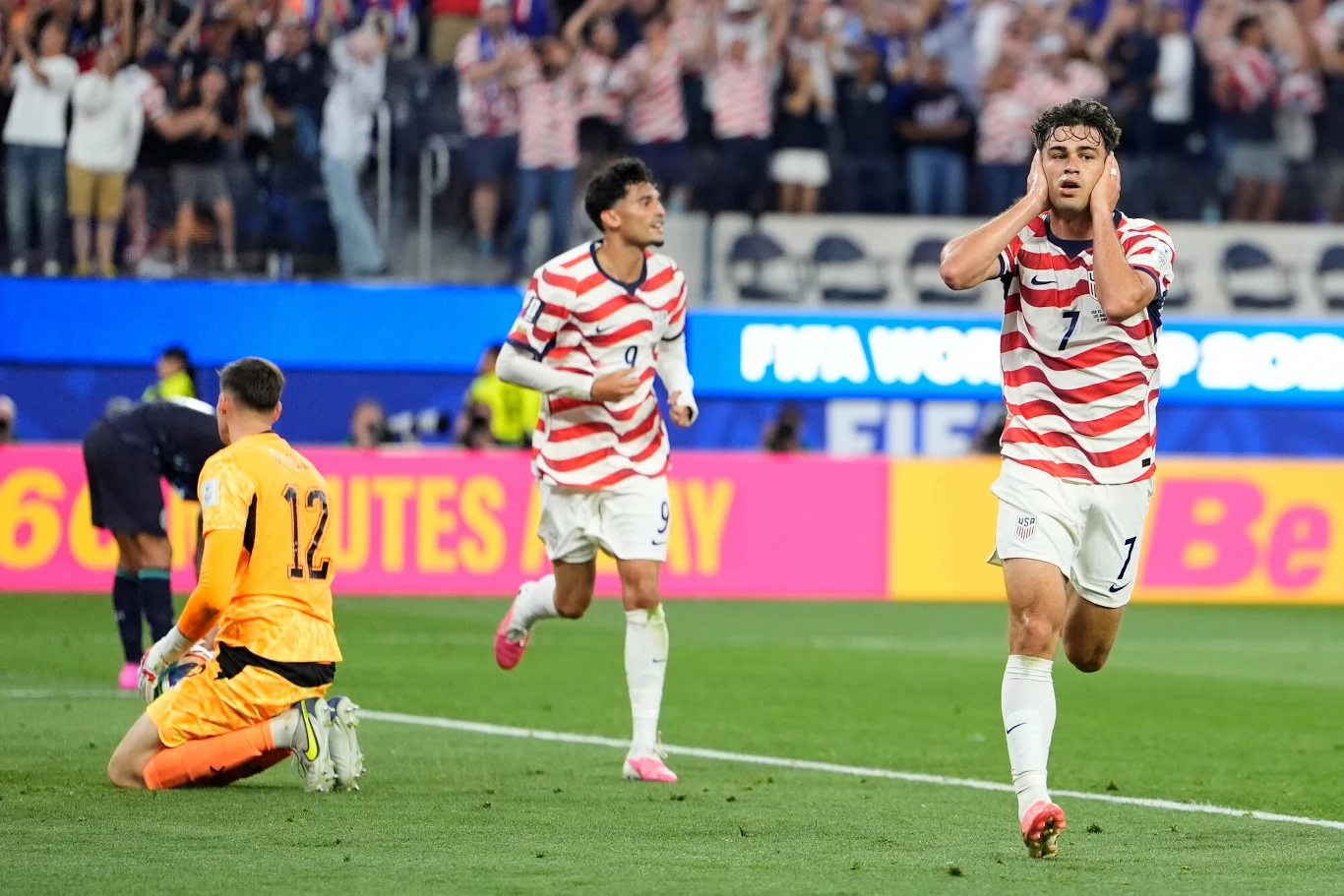 Giovanni Reyna po golu na 4:1, USA - Paragwaj na MŚ 2026 Piłkarz w pasiastym stroju świętuje zdobycie gola, trzymając ręce przy głowie, podczas gdy bramkarz w żółtym stroju klęczy na murawie, z tyłu widoczny drugi zawodnik biegnący z uniesioną ręką.