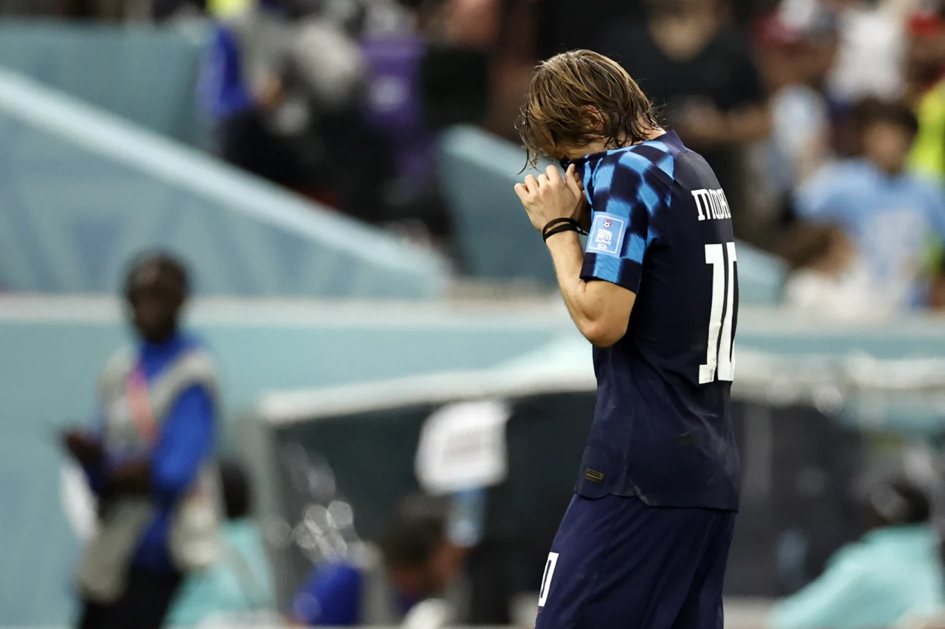 Luka Modrić, półfinał MŚ 2022 Argentyna - Chorwacja Luka Modrić w granatowym stroju z numerem 10 i opaską kapitana zakrywa twarz dłonią podczas meczu MŚ 2022.