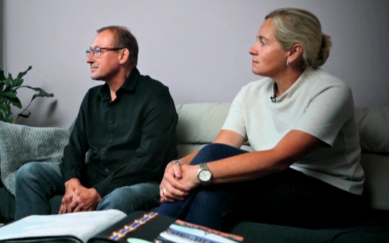 Tomasz i Marcela Chwalińscy Dwie osoby siedzące na sofie, kobieta w jasnej bluzce i mężczyzna w ciemnej koszuli, zwrócone bokiem, z otwartymi albumami na kolanach.