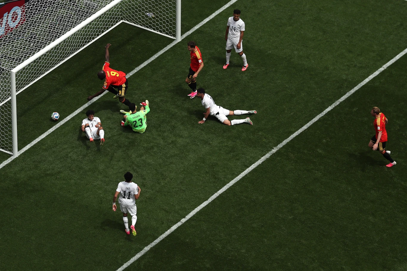 Piłka w bramce "Faraonów". Chwilę wcześniej na murawie pojawił się Romelu Lukaku (nr 9) Piłkarz w czerwonej koszulce oddający strzał na bramkę, kilku zawodników rywalizujących przy polu bramkowym oraz bramkarz usiłujący zatrzymać piłkę tuż przy linii bramkowej.