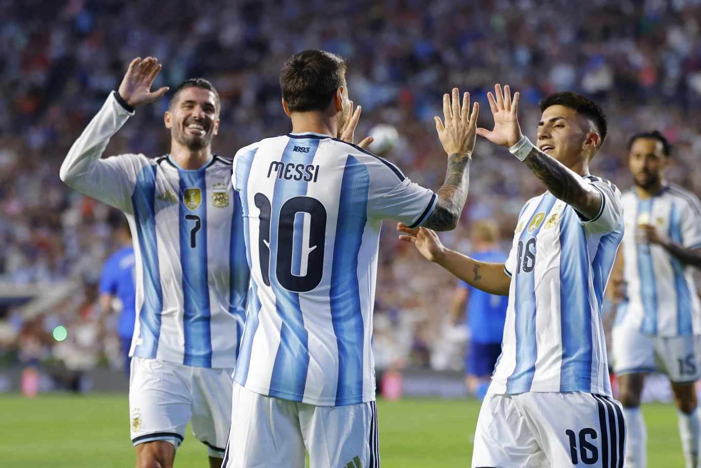 Piłkarze reprezentacji Argentyny w biało-błękitnych koszulkach celebrują zdobycie gola, podnosząc ręce do wspólnego przybicia piątki na murawie stadionu.