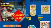 Kolorowe wrotki z kwiatowym wzorem na tle dżinsów oraz wybór słodyczy: lizaki, cukierki, gumy kulki i pastylki w atrakcyjnych cenach, podkreślające motyw kultowych smaków i nostalgii do lat młodości.