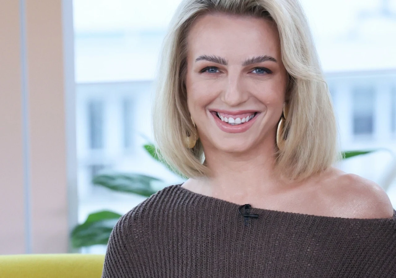 Daria Rybak-Lenz z "Love is Blind:Polska" Daria Rybak-Lenz z programu Love is Blind: Polska siedząca na żółtej sofie w studiu telewizyjnym.