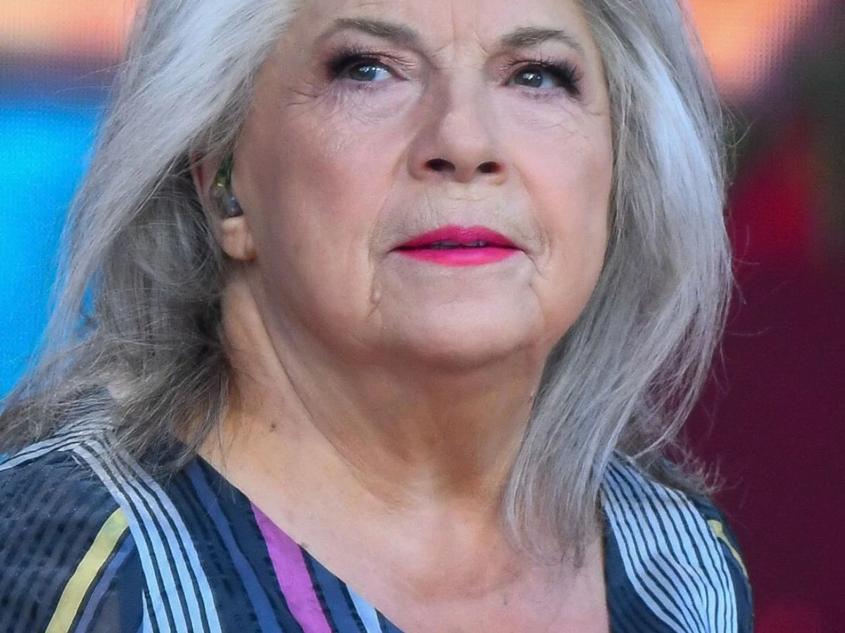 Krystyna Prońko Krystyna Prońko z siwymi włosami, w wzorzystej bluzce i z wyrazistym makijażem ust, patrzy przed siebie.