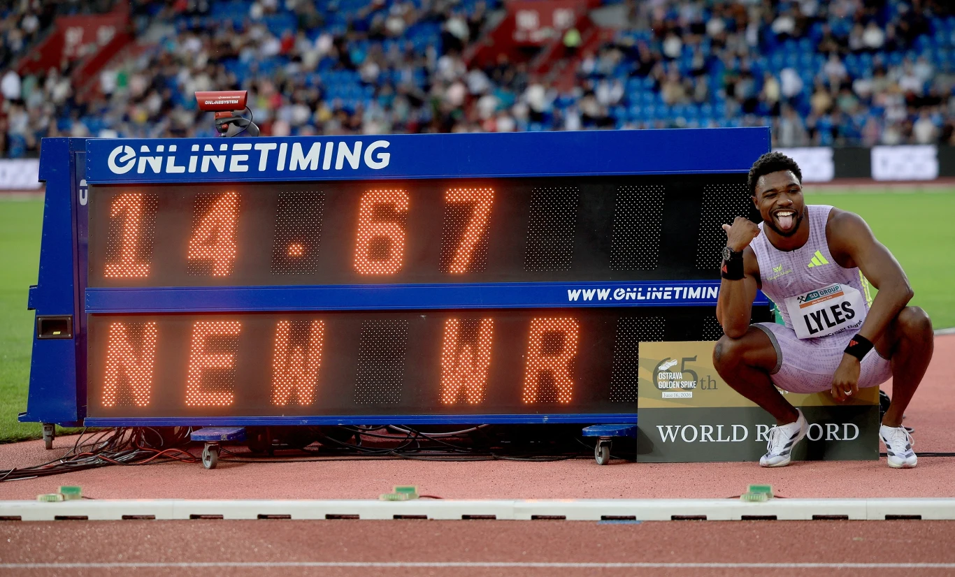 Noah Lyles napisał nową historię w biegu na 150 metrów Lekkoatleta w stroju sportowym kuca obok elektronicznego wyświetlacza z wynikiem 14.67 i napisem „NEW WR”, wyrażając radość z ustanowienia nowego rekordu świata.