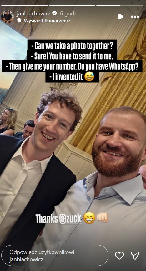 Dwóch uśmiechniętych mężczyzn pozuje do wspólnego selfie w eleganckim wnętrzu z ozdobnymi, złotymi zasłonami w tle.