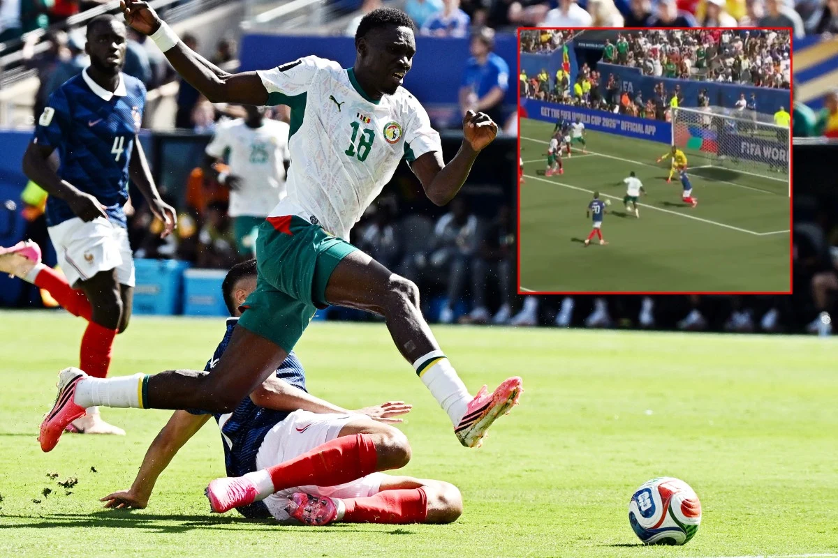 Francja - Senegal Piłkarz Senegalu w zielono-białym stroju przeskakuje nad przeciwnikiem wykonującym wślizg, obok piłka.