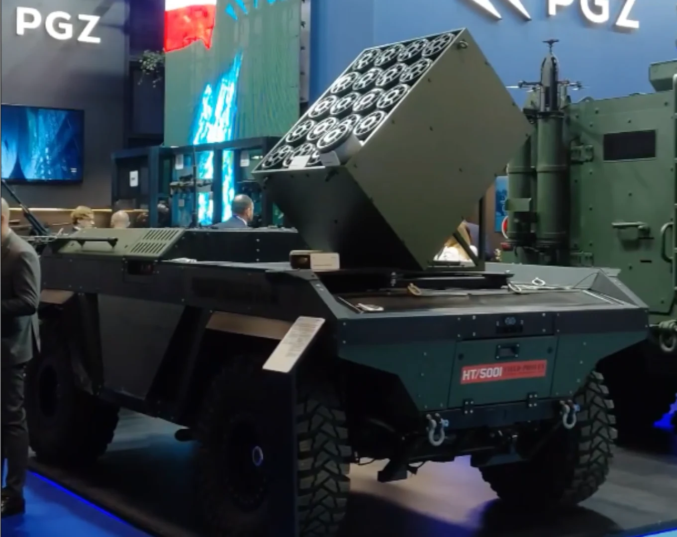 Modułowy System Minowania Narzutowego na platformie PIAP HUNTeR na targach Eurosatory 2026. Opancerzony pojazd wojskowy z zamontowaną wielolufową wyrzutnią rakietową na obracanej platformie, prezentowany podczas wystawy zbrojeniowej na tle ekspozycji z logo PGZ.