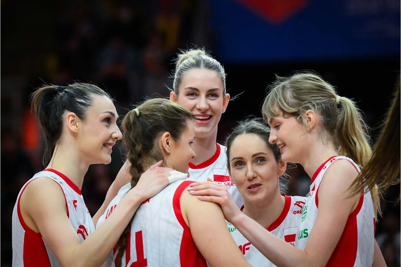 Magdalena Stysiak (w środku) znów gra w reprezentacji Polski Pięć zawodniczek reprezentacji Polski w siatkówce, uśmiechnięte i obejmujące się, tworzy zwarty krąg na boisku, wyrażając radość i sportową solidarność.