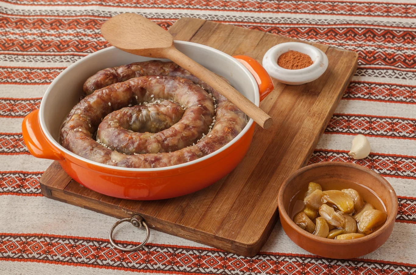 To danie jest królową podlaskiego stołu. Kiszkę przygotujesz z prostych składników, a jej bazą są ziemniaki Kiszka ziemniaczana ułożona spiralnie w naczyniu żaroodpornym, z przyprawą i czosnkiem na drewnianej desce.