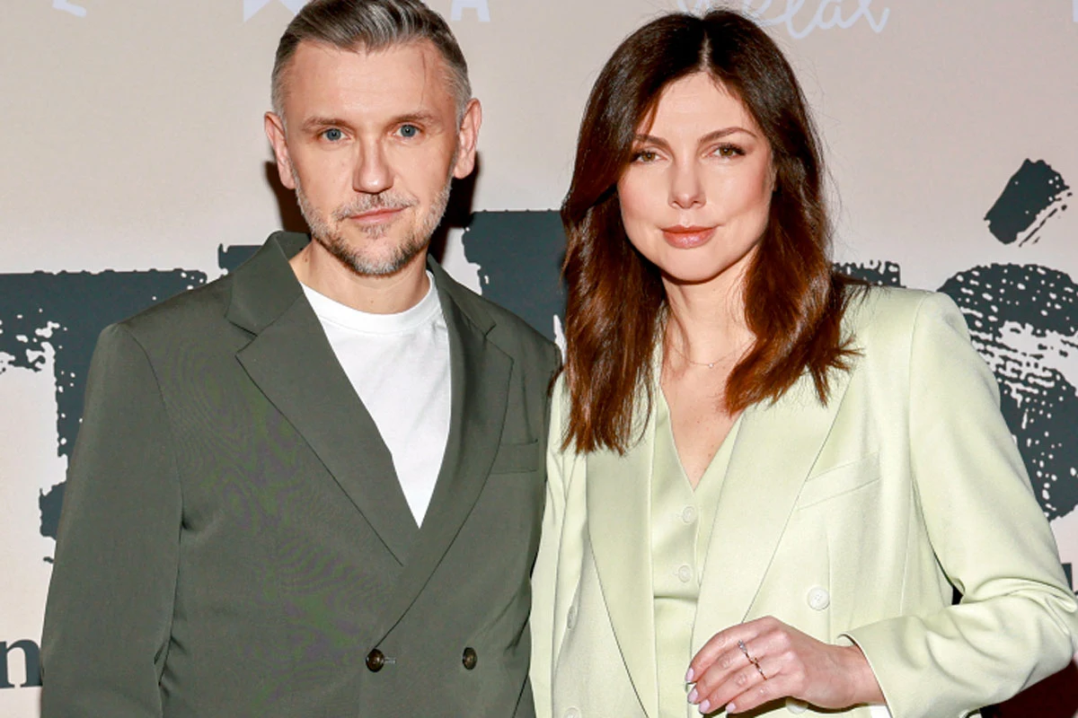 Krzysztof Czeczot i Karolina Gorczyca Krzysztof Czeczot i Karolina Gorczyca stoją razem, ubrani elegancko, na tle ściany z graficznym motywem.